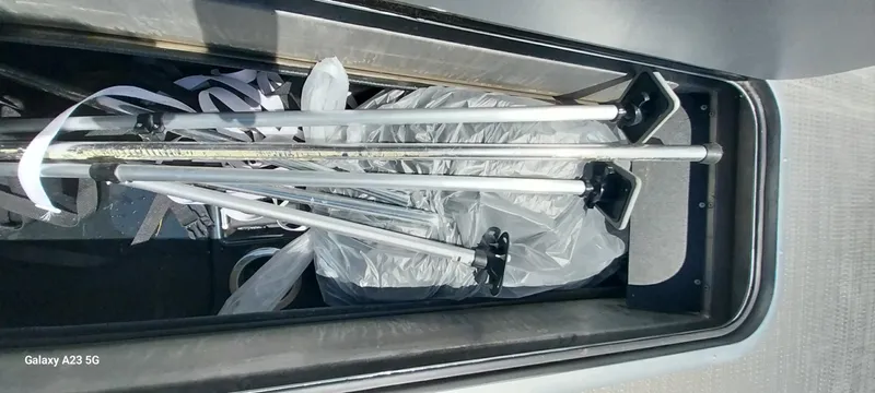 Slide: The Image of Storage compartment of 2023 Regency 250 LE3 Sport with poles and equipment inside. - 44