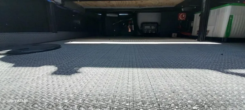 Slide: The Image of Under-seat storage area of 2023 Regency 250 LE3 Sport boat, featuring carpeted flooring. - 48