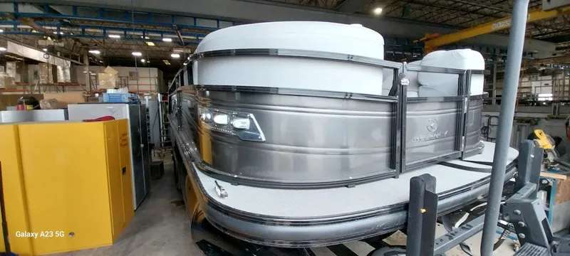Slide: The Image of 2023 Regency 250 LE3 Sport pontoon boat in a warehouse setting. - 49