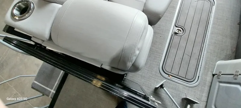 Slide: The Image of 2023 Regency 250 LE3 Sport boat interior with gray seating and flooring. - 9