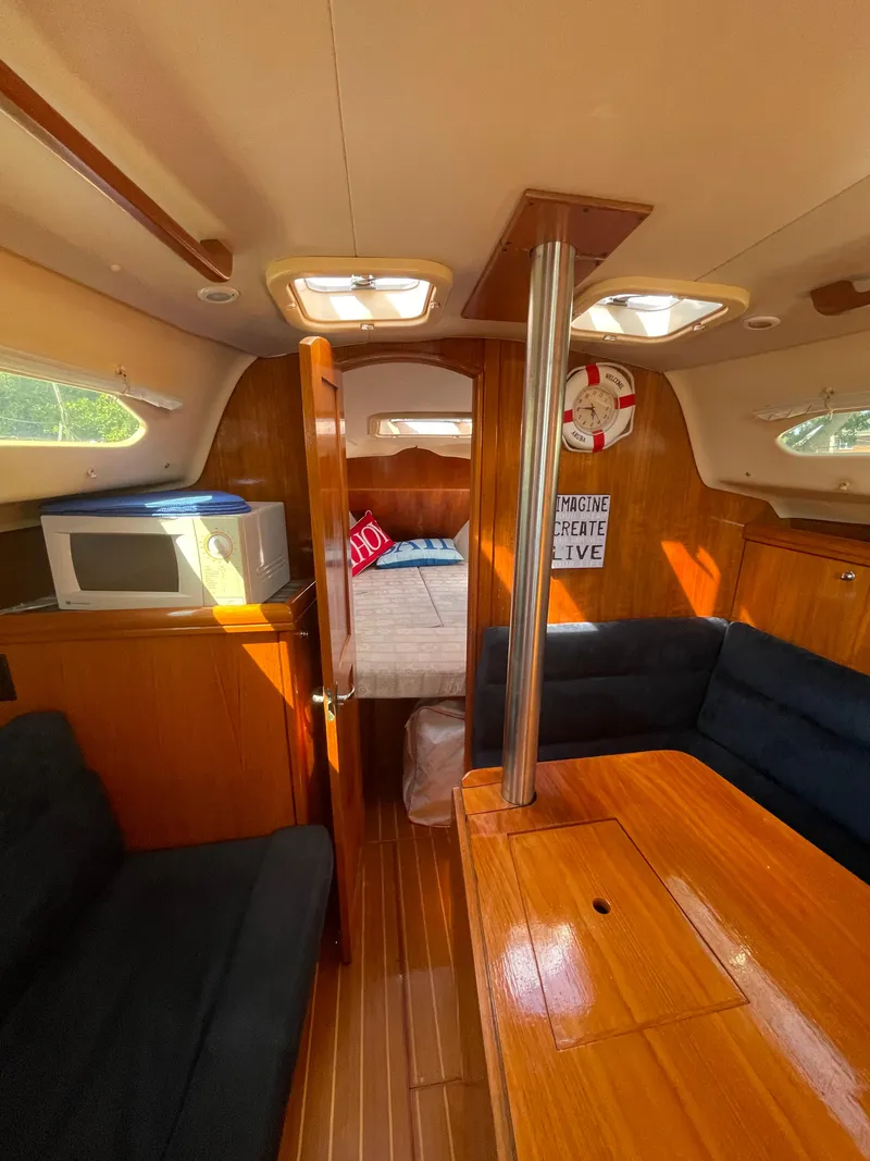 Slide: The Image of Interior of a 2001 Hunter 306 sailboat with cozy seating and wooden finishes. - 10