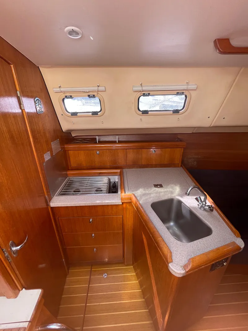 Slide: The Image of 2001 Hunter 306 yacht interior kitchen with wooden cabinetry and stainless steel sink. - 22