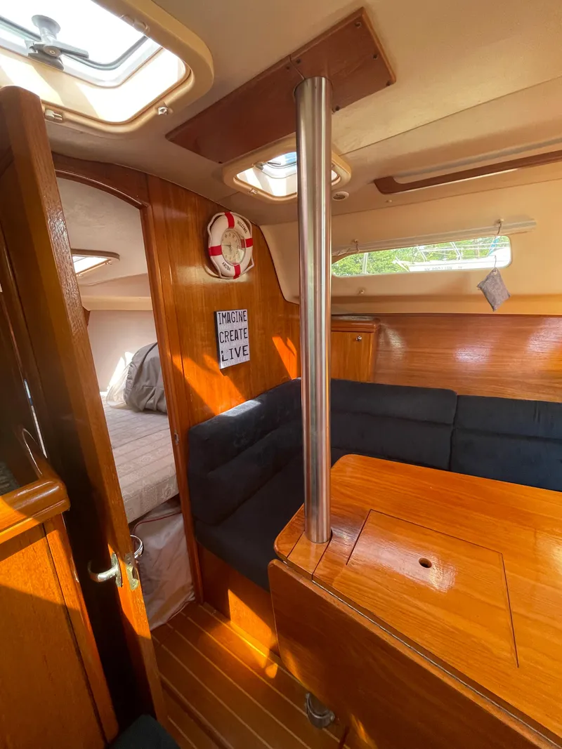 Slide: The Image of Interior of 2001 Hunter 306 sailboat with cozy seating and wooden finishes. - 23