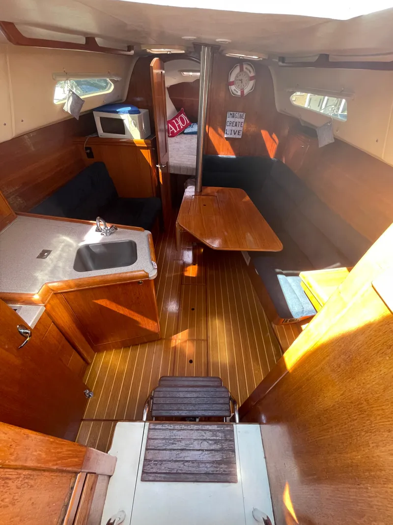 Slide: The Image of Interior of 2001 Hunter 306 sailboat with wood finish, kitchenette, and seating area. - 27