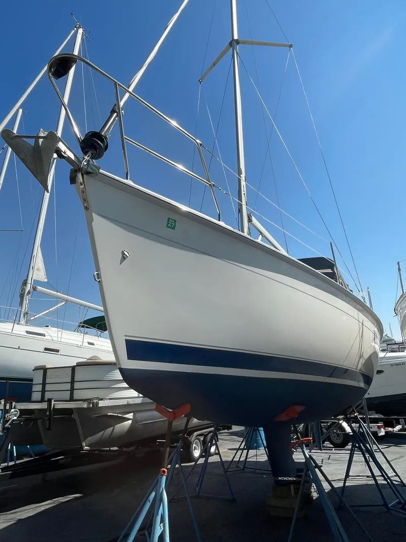 Slide: The Image of 2001 Hunter 306 sailboat on stands, viewed from below, under clear blue sky. - 28