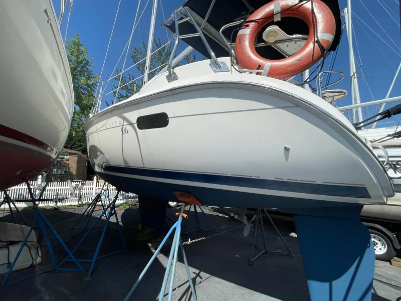 Slide: The Image of 2001 Hunter 306 sailboat on stands, with a visible life preserver and clear blue sky. - 3