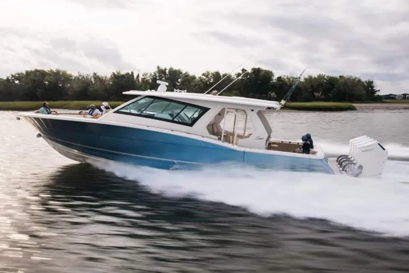 Slide: The Image of Manufacturer Provided Image: 2025 Scout 530 LXF boat cruising on a calm river. - 2