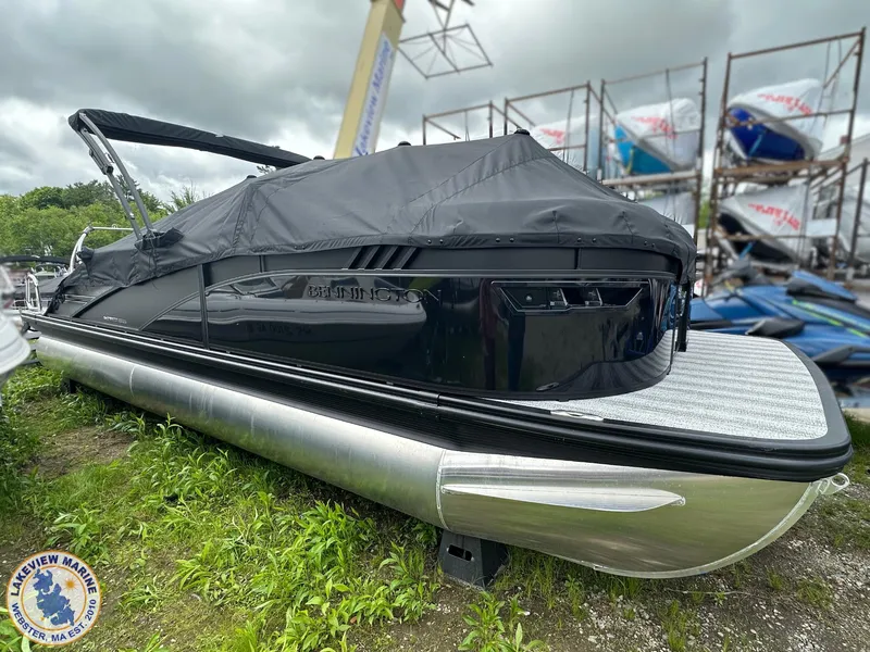 Slide: The Image of 2025 Bennington 23 LXSSB pontoon boat with cover, displayed outdoors. - 13