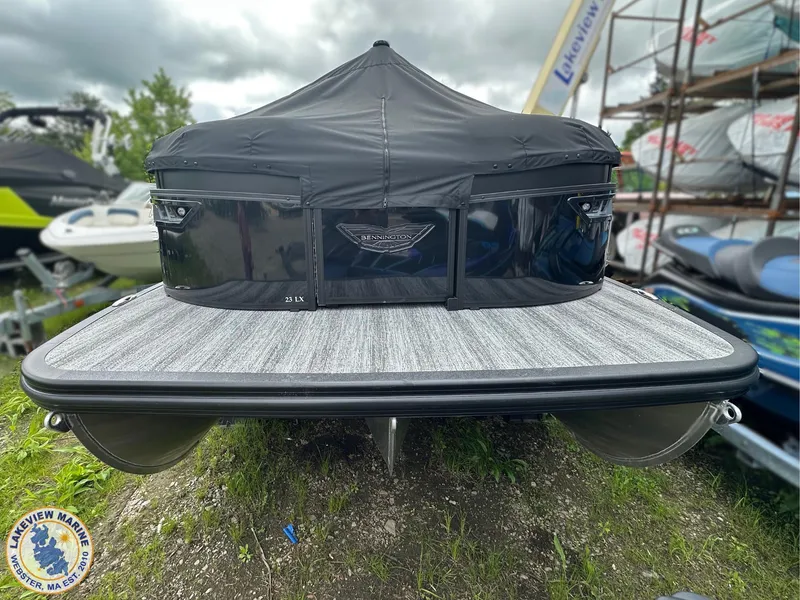Slide: The Image of 2025 Bennington 23 LXSSB pontoon boat with cover, displayed outdoors at Lakeview Marine. - 14