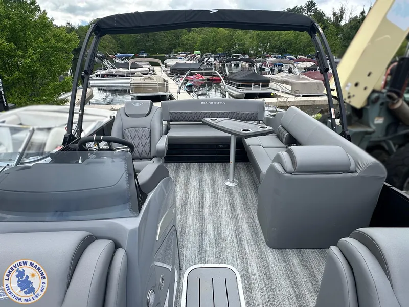 Slide: The Image of 2025 Bennington 23 LXSSB pontoon boat with luxurious seating and modern design at a marina. - 7