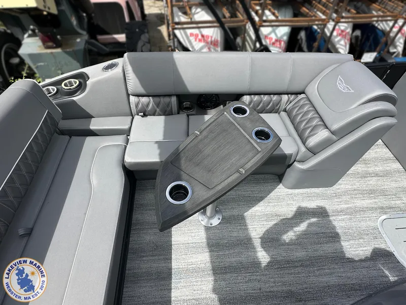 Slide: The Image of 2025 Bennington 23 LXSSB boat interior with gray seating and table, featuring cup holders. - 8