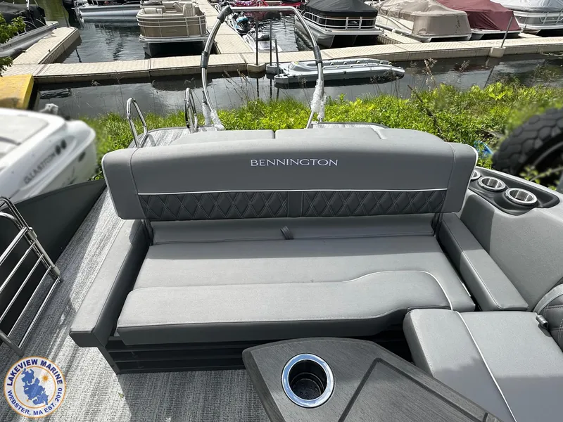 Slide: The Image of 2025 Bennington 23 LXSSB pontoon boat with gray seating at a marina. - 9