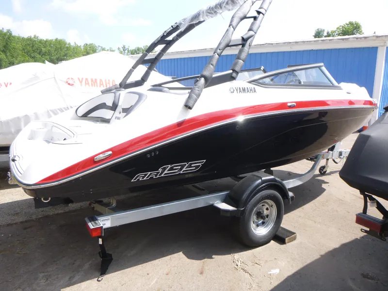 The Image of 2025 Yamaha AR195 boat on trailer, black and red design, outdoor display. - 1