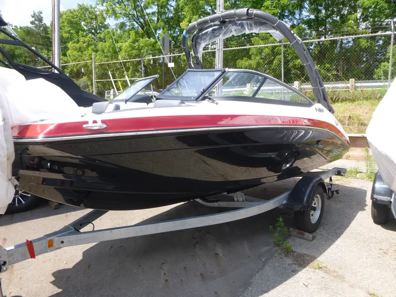 Slide: The Image of 2025 Yamaha AR195 boat on trailer, black and red design, parked outdoors. - 3