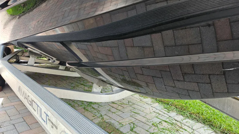 Slide: The Image of 2021 Scout 231 XS boat hull on Magic Tilt trailer, parked on brick pavement. - 10