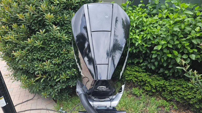 Slide: The Image of Black outboard motor on a 2021 Scout 231 XS boat, surrounded by lush greenery. - 17