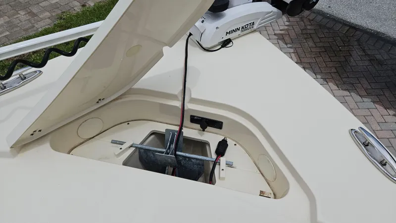 Slide: The Image of Open anchor compartment on 2021 Scout 231 XS boat with Minn Kota motor. - 29