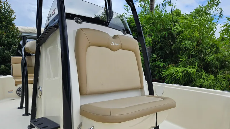 Slide: The Image of 2021 Scout 231 XS boat with tan seating and lush greenery background. - 32