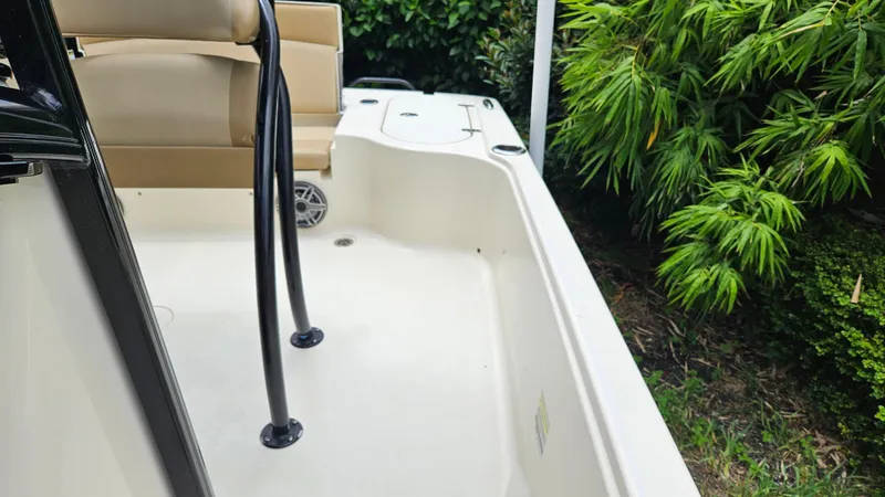 Slide: The Image of 2021 Scout 231 XS boat interior with seating, surrounded by lush greenery. - 35