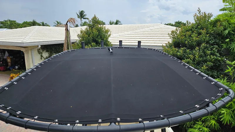 Slide: The Image of Black canvas top on 2021 Scout 231 XS boat, surrounded by greenery and rooftops. - 37