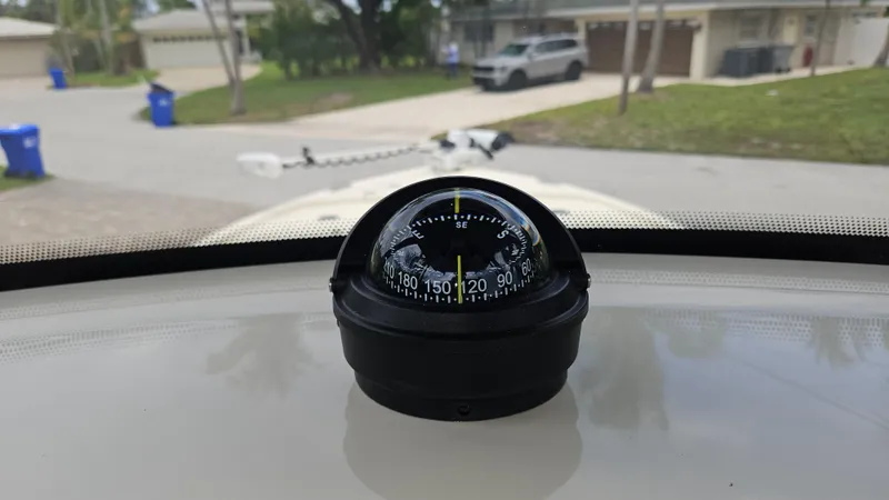 Slide: The Image of Compass on 2021 Scout 231 XS boat dashboard, street view in background. - 42