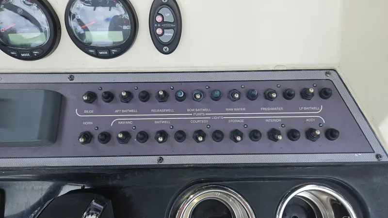 Slide: The Image of Control panel of a 2021 Scout 231 XS boat with various switches and gauges. - 47