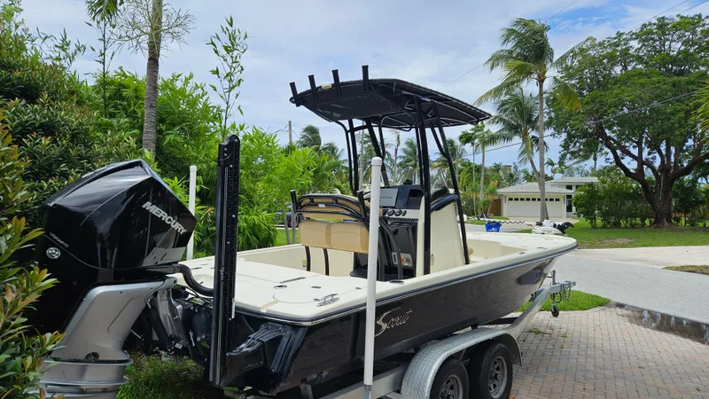 Slide: The Image of 2021 Scout 231 XS boat on trailer with Mercury engine, surrounded by tropical greenery. - 5