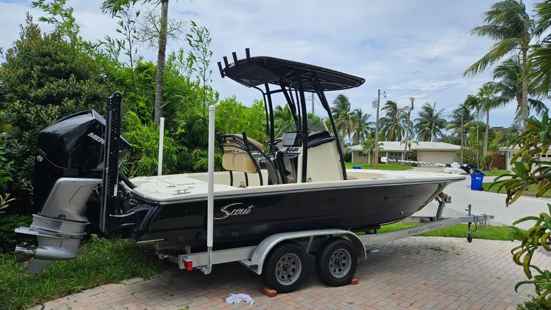 Slide: The Image of 2021 Scout 231 XS boat on trailer, parked in a tropical residential area. - 8