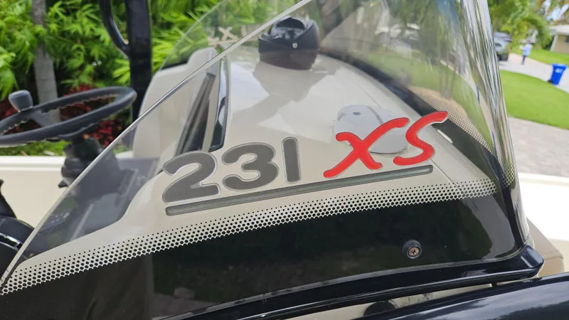 Slide: The Image of 2021 Scout 231 XS boat windshield with logo, steering wheel visible in background. - 9