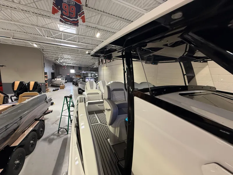 Slide: The Image of 2024 Sunsation 34 CCX boat in a showroom, featuring sleek design and modern seating. - 13