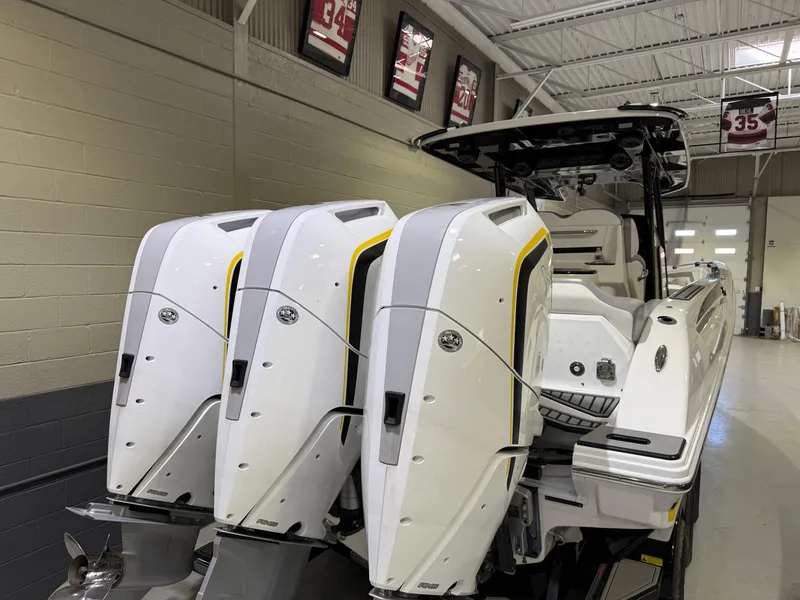 Slide: The Image of 2024 Sunsation 34 CCX boat with triple outboard engines in a showroom. - 4
