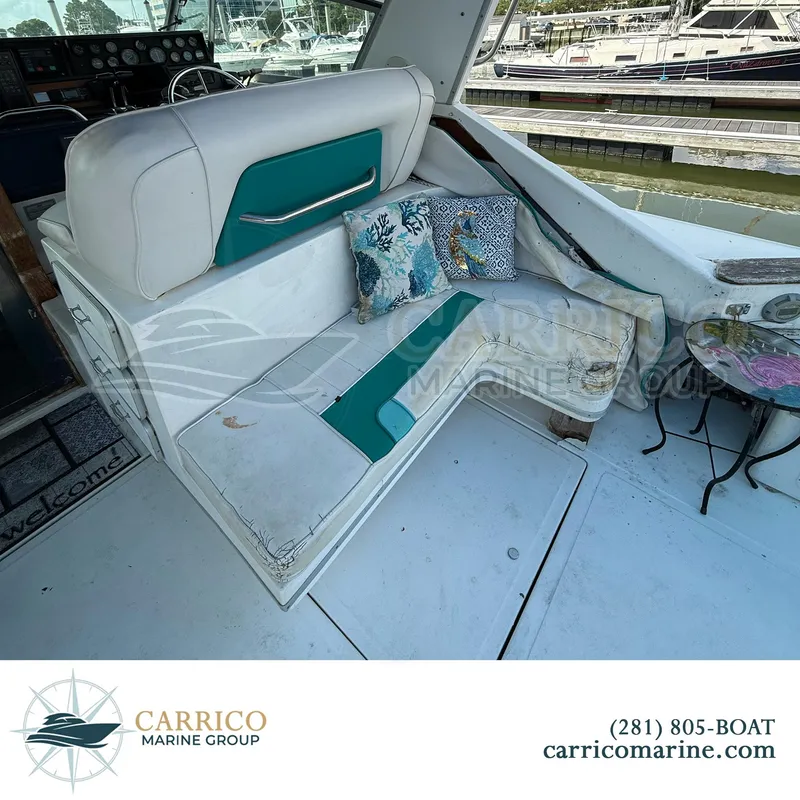 Slide: The Image of 1990 Sea Ray 390 Express Cruiser interior with seating and decorative pillows. - 11