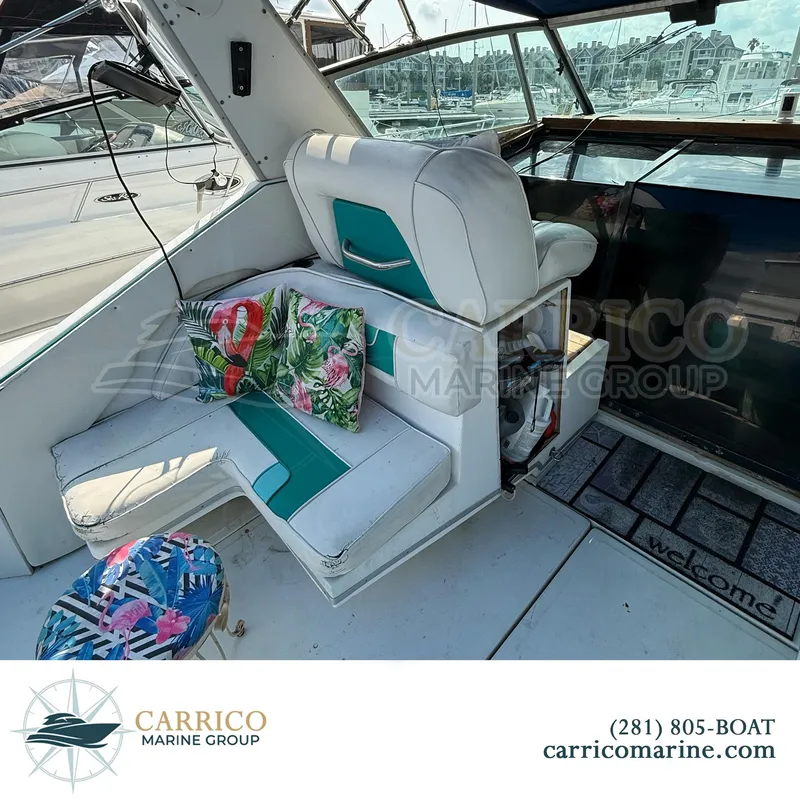 Slide: The Image of 1990 Sea Ray 390 Express Cruiser interior with tropical cushions and marina view. - 12
