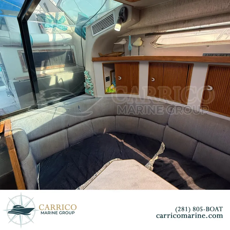 Slide: The Image of Interior of 1990 Sea Ray 390 Express Cruiser with cozy seating and wooden cabinets. - 17