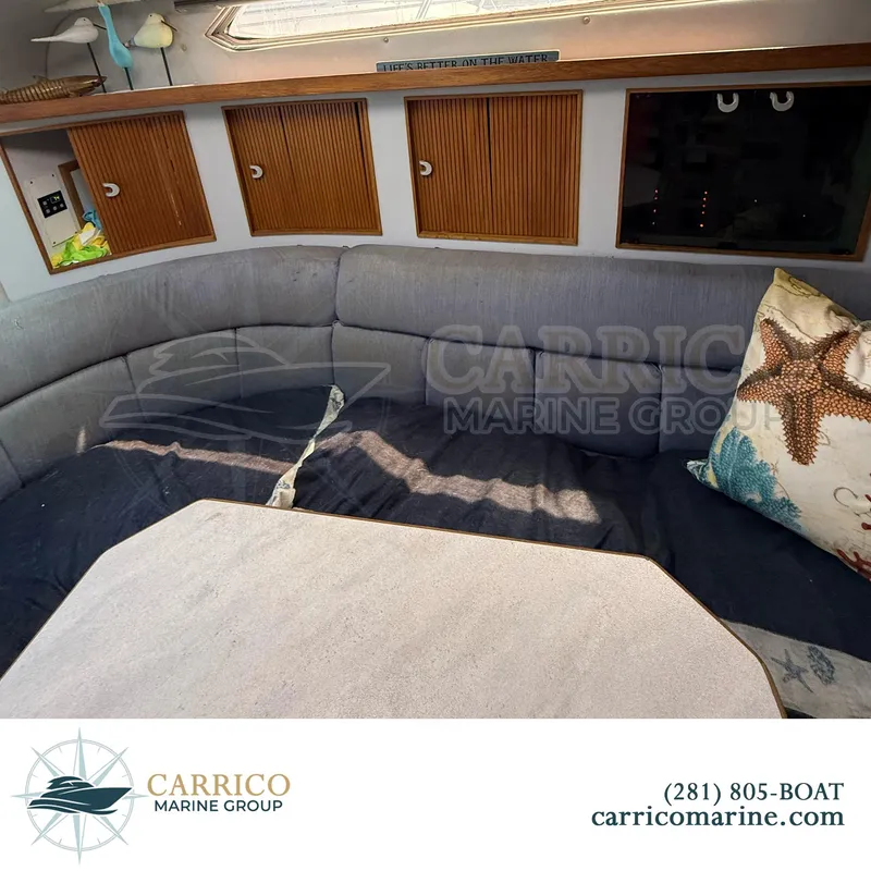 Slide: The Image of 1990 Sea Ray 390 Express Cruiser interior with cozy seating and decorative pillows. - 18