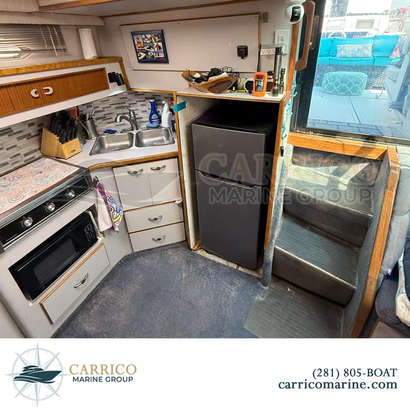 Slide: The Image of Interior of 1990 Sea Ray 390 Express Cruiser with kitchen and stairs. - 20