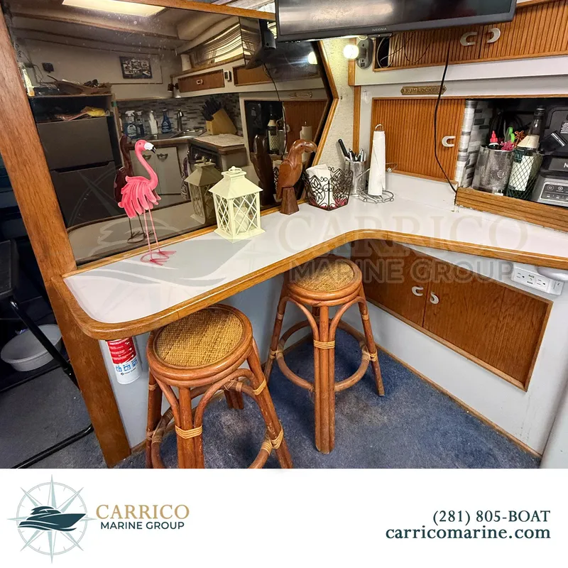 Slide: The Image of Interior of 1990 Sea Ray 390 Express Cruiser with bar stools and decorative items. - 23