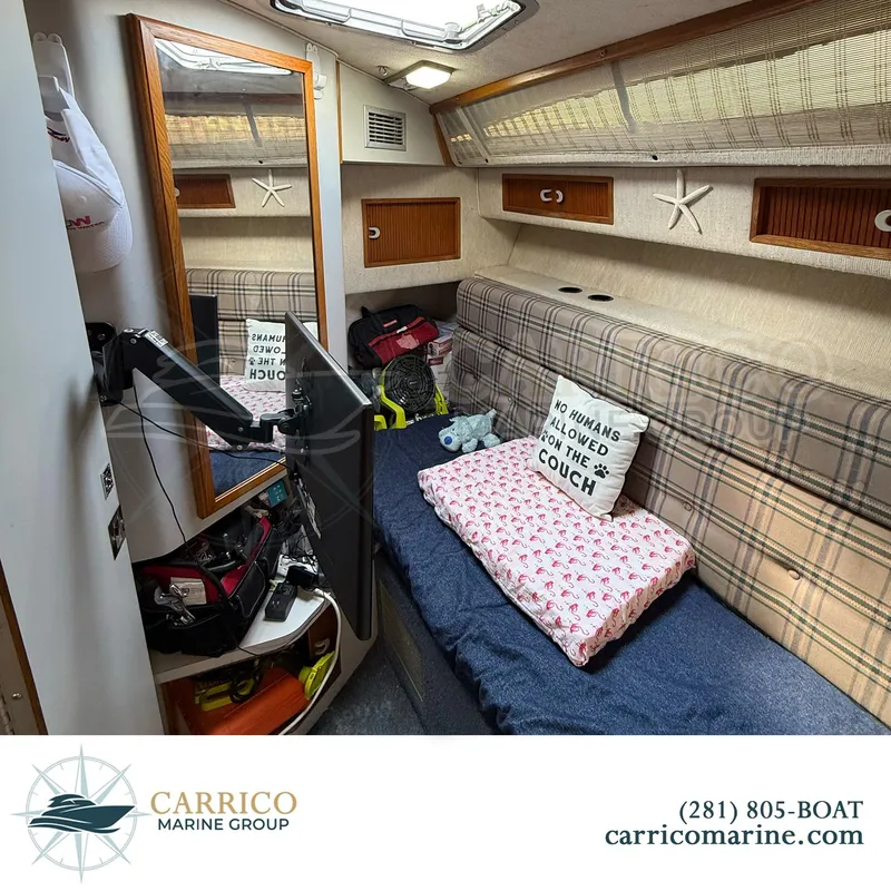 Slide: The Image of 1990 Sea Ray 390 Express Cruiser cabin with plaid seating, mirror, and humorous pillow. - 24