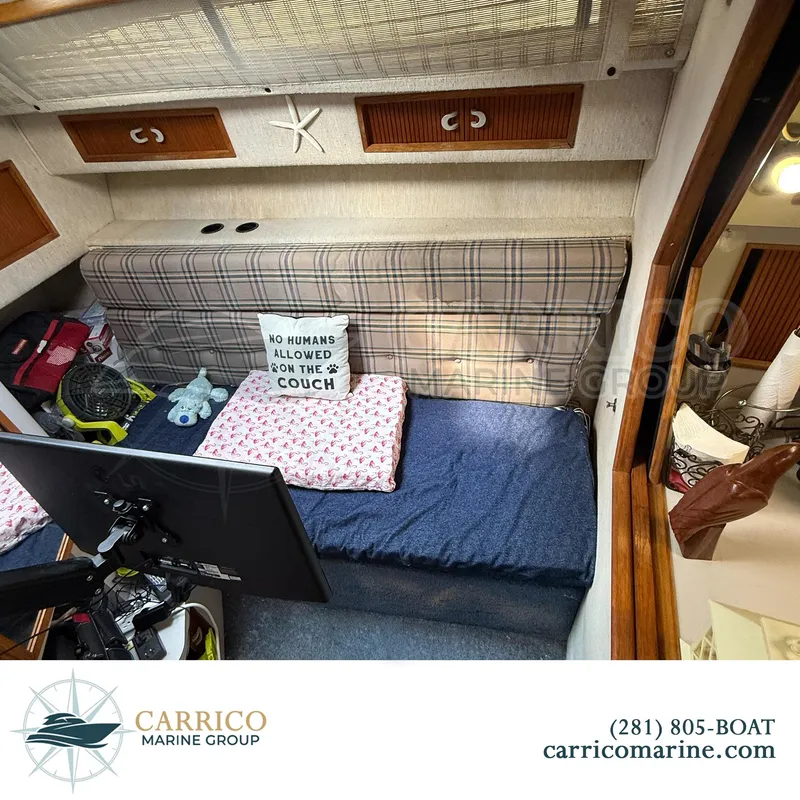 Slide: The Image of 1990 Sea Ray 390 Express Cruiser cabin with plaid couch, decorative pillow, and marine accessories. - 25