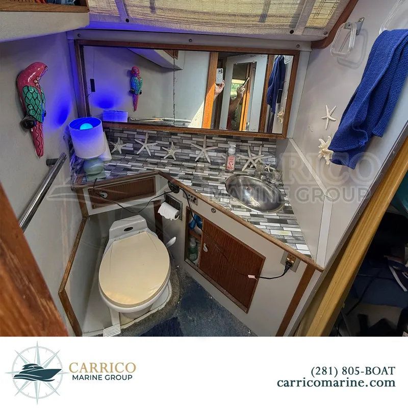 Slide: The Image of 1990 Sea Ray 390 Express Cruiser bathroom with nautical decor and compact design. - 26