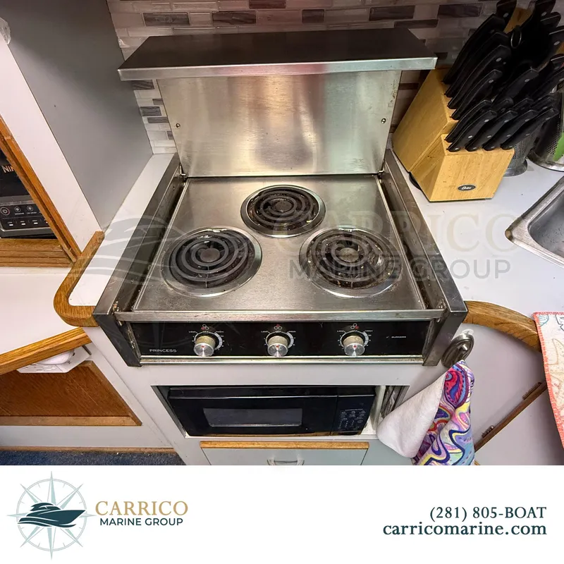 Slide: The Image of Electric stove in 1990 Sea Ray 390 Express Cruiser kitchen, with three burners and oven. - 28