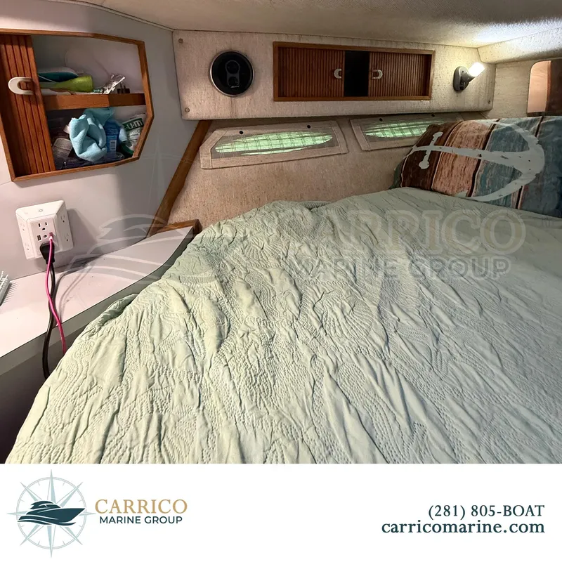 Slide: The Image of 1990 Sea Ray 390 Express Cruiser cabin interior with bed and storage shelves. - 32