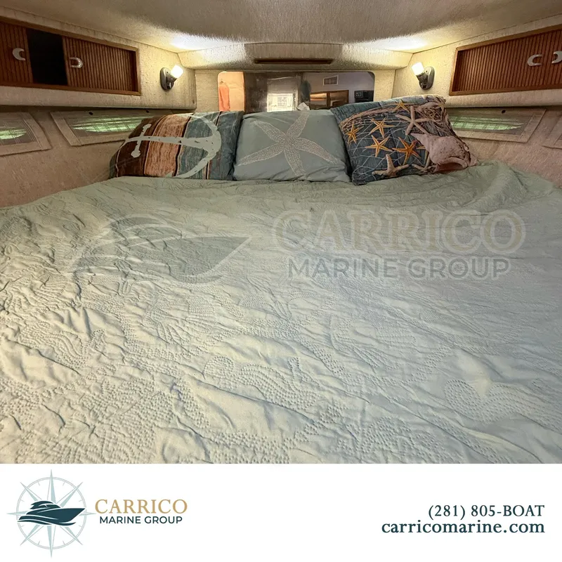 Slide: The Image of Cozy cabin interior of 1990 Sea Ray 390 Express Cruiser with nautical-themed bedding. - 33