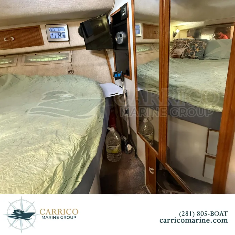 Slide: The Image of Interior of 1990 Sea Ray 390 Express Cruiser with bed, mirror, and storage. - 34