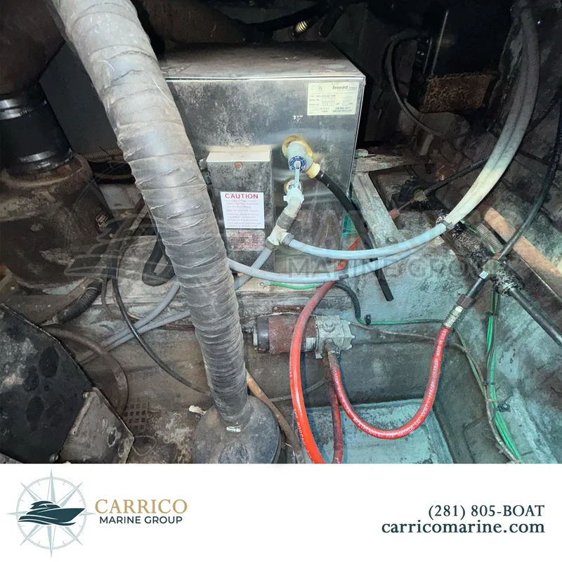 Slide: The Image of Engine compartment of a 1990 Sea Ray 390 Express Cruiser with various hoses and components. - 46