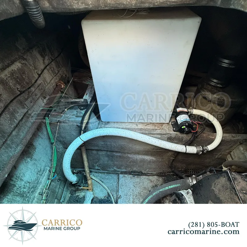 Slide: The Image of Engine compartment of a 1990 Sea Ray 390 Express Cruiser with visible hoses and equipment. - 47