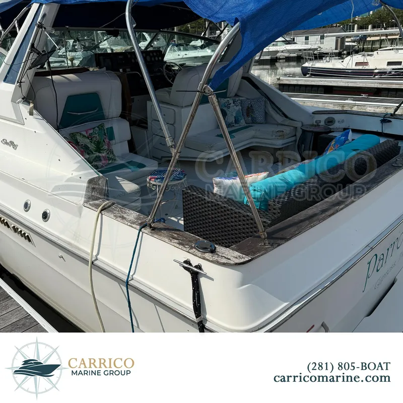 Slide: The Image of 1990 Sea Ray 390 Express Cruiser docked with blue canopy and plush seating. - 5
