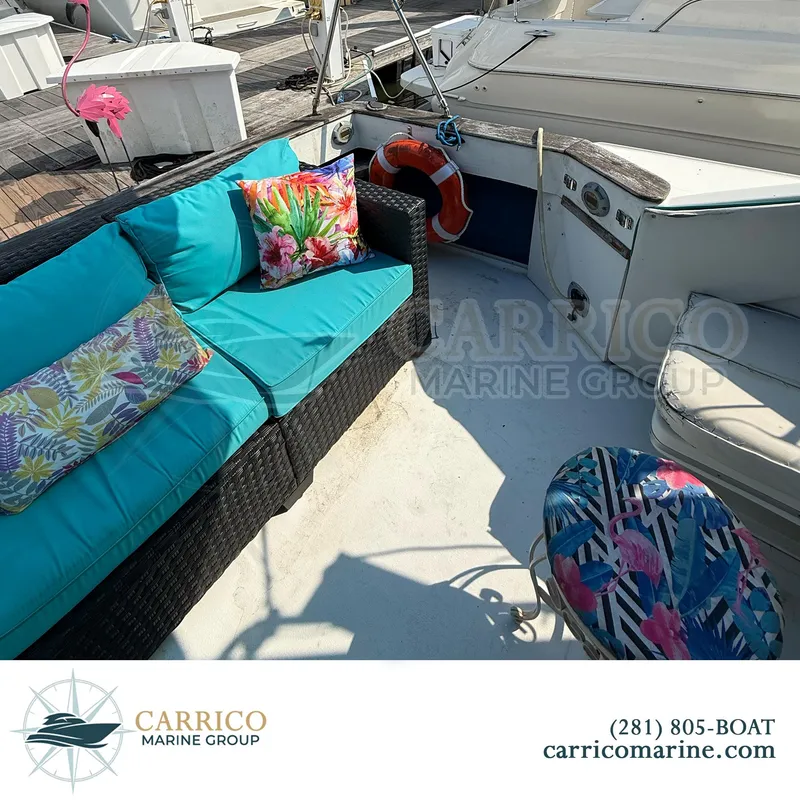 Slide: The Image of 1990 Sea Ray 390 Express Cruiser deck with colorful cushions and seating area. - 9