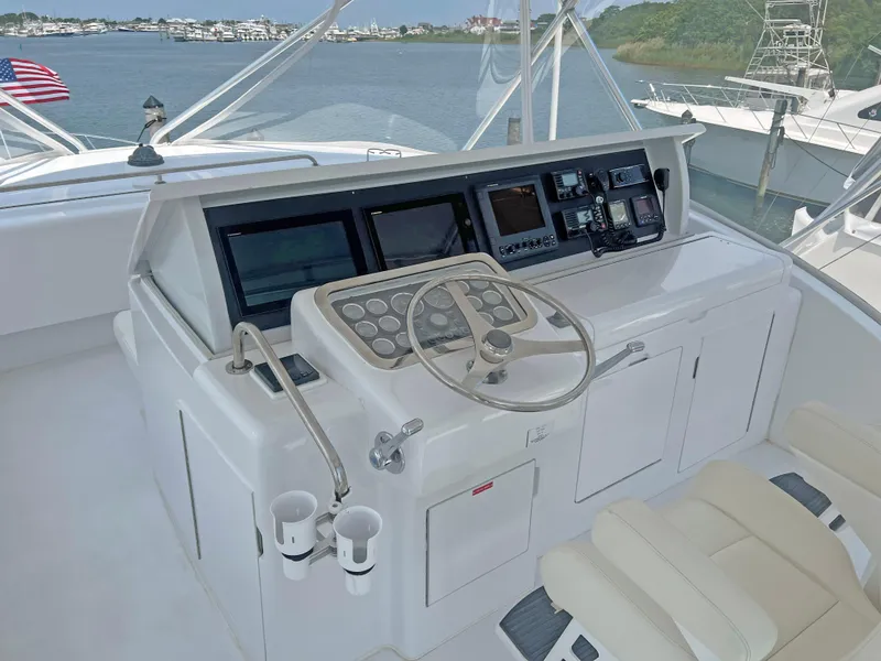Slide: The Image of Control panel of a 2000 Hatteras 60 Convertible yacht with steering wheel and navigation screens. - 10