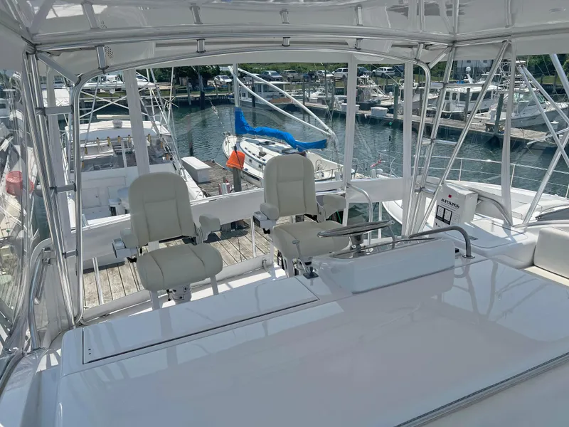 Slide: The Image of Hatteras 60 Convertible 2000 yacht interior with helm chairs and marina view. - 13